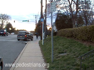 Signposts behind sidewalk.