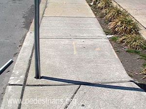 Signpost in sidewalk.