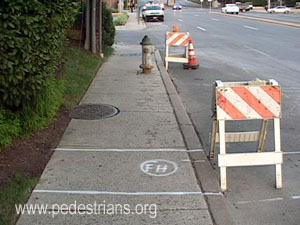 Old and planned WSSC hydrants block sidewalk.
