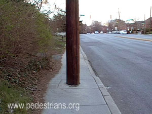 Utility poles block sidewalk.